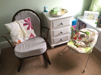 Rocking chair next to upcycled drawers and baby bouncer