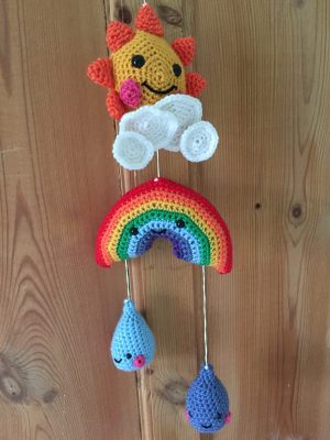 Crocheted weather mobile hanging on the back of nursery door