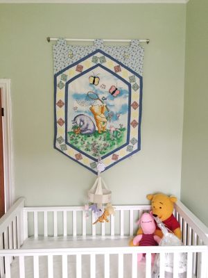 Vintage classic Winnie the Pooh wall hanging above the cot