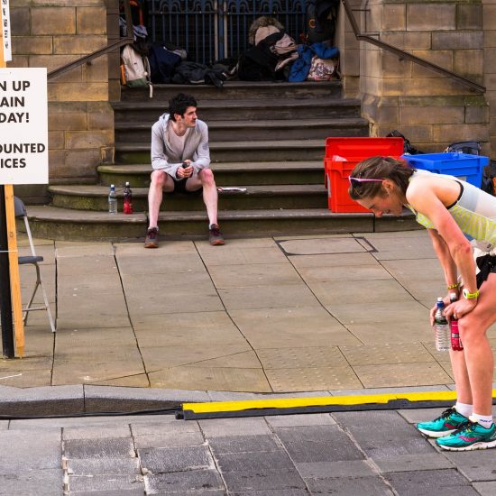 Marathon runner taking a breather with a sign saying 'Sign up again today! Discounted prices'