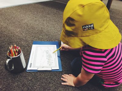 Tall Boy colouring, wearing a yellow hat at Salford Art Gallery