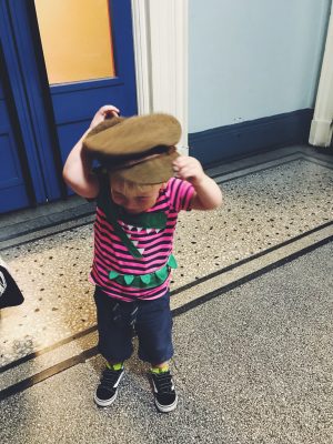Tall Boy trying on an army hat at Salford Museum