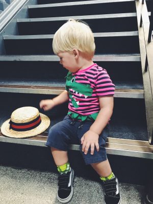 Tall Boy trying on a straw boater at Salford Museum