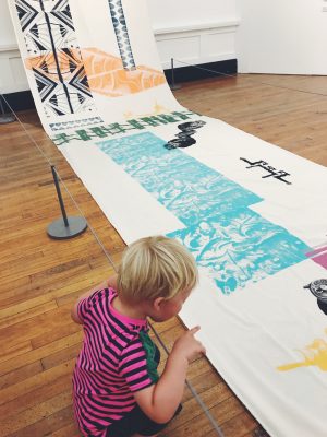 Tall Boy investigating a print at Salford Art Gallery