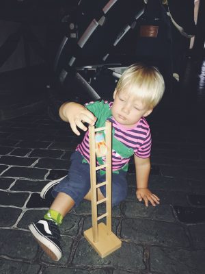 Tall Boy playing with old fashioned toys at Lark Hill Place, Salford Museum