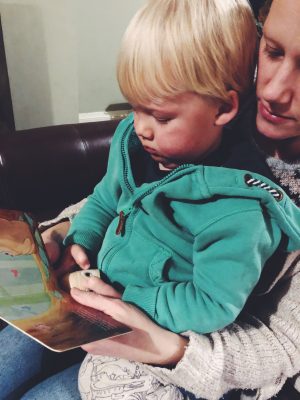 Tall Boy reading Sounds of the Forest and holding owl whistle