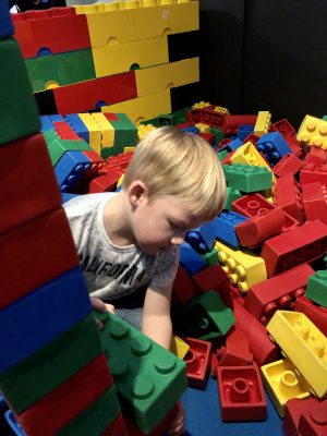 Tall Boy playing with foam Lego bricks